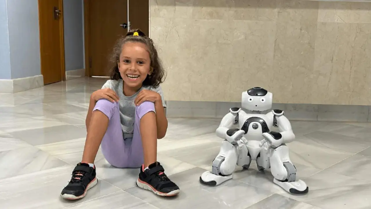 Una ni&ntilde;a junto al robot terap&eacute;uta 
