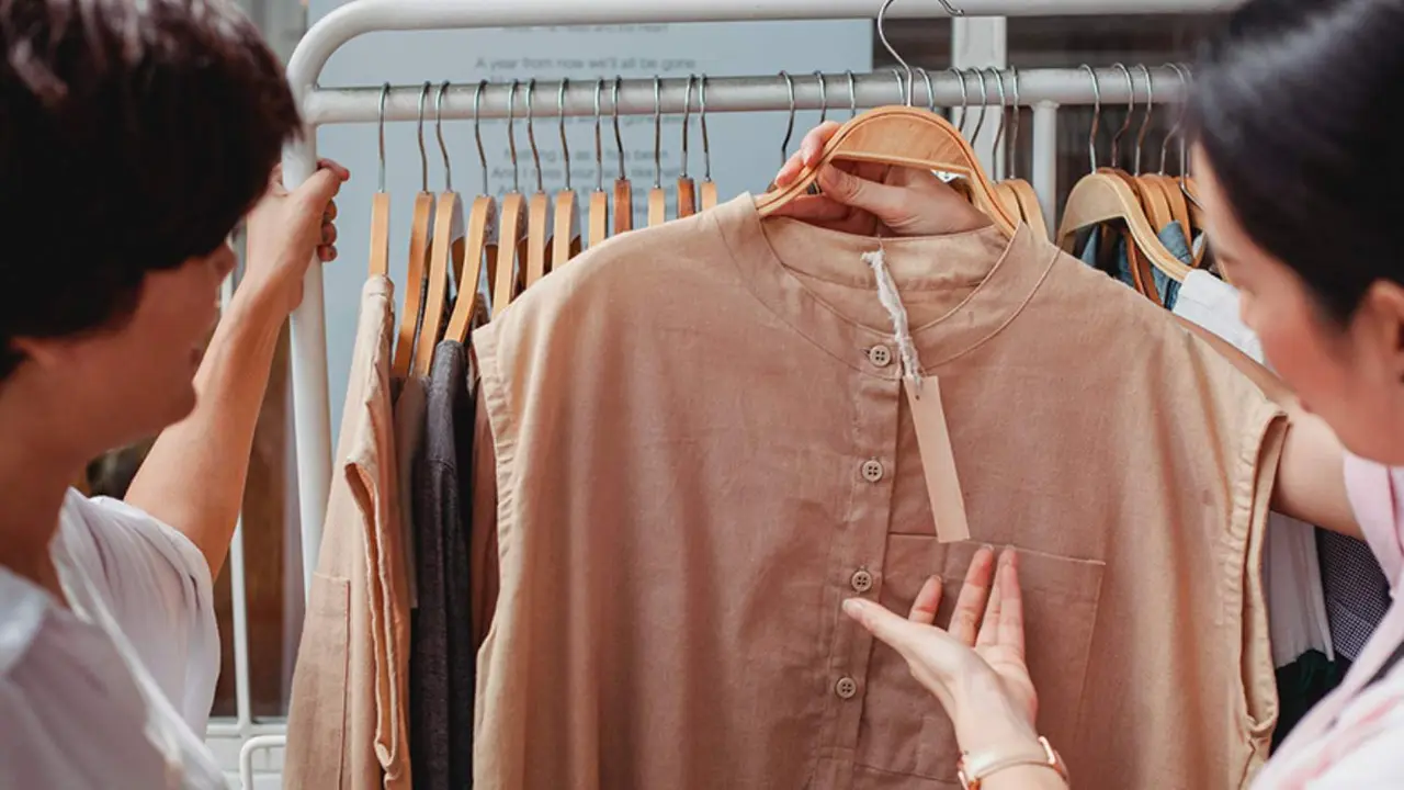  Una clienta comprueba el precio de una prenda rebajada en una tienda. 