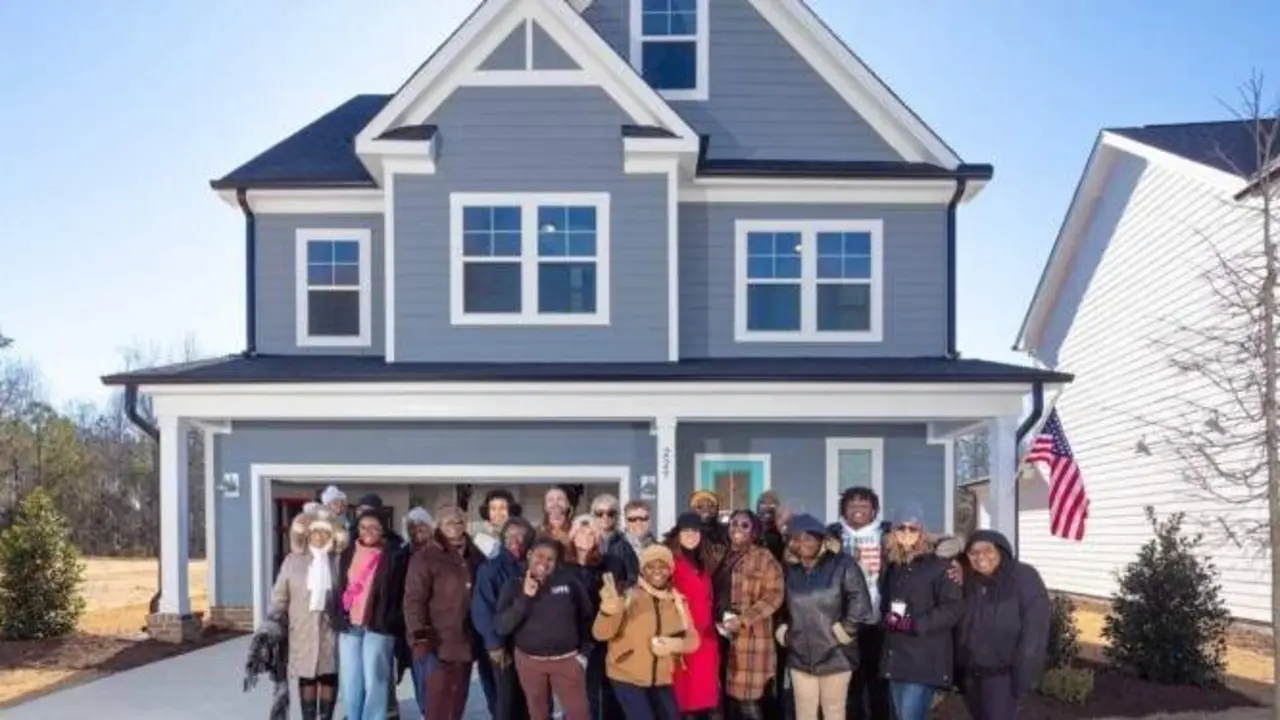  Familia del soldado ca&iacute;do y voluntarios en la nueva casa 