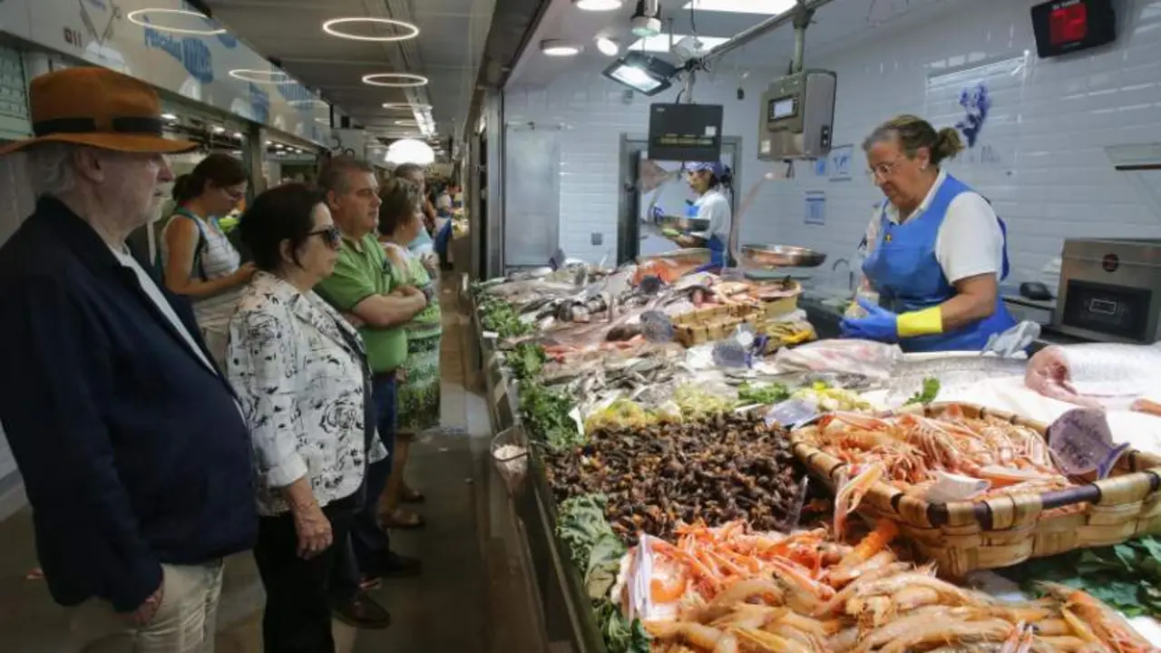  Varias personas comprando alimentos en un mercado 
