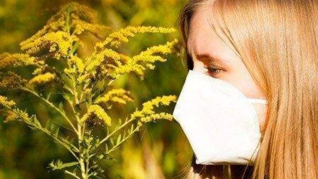  Chica con mascarilla frente a flores. ARCHIVO 