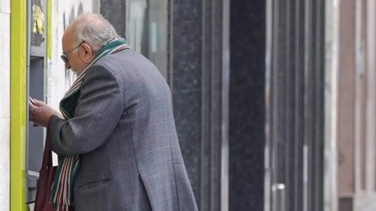  Persona mayor sacando dinero de un cajero 