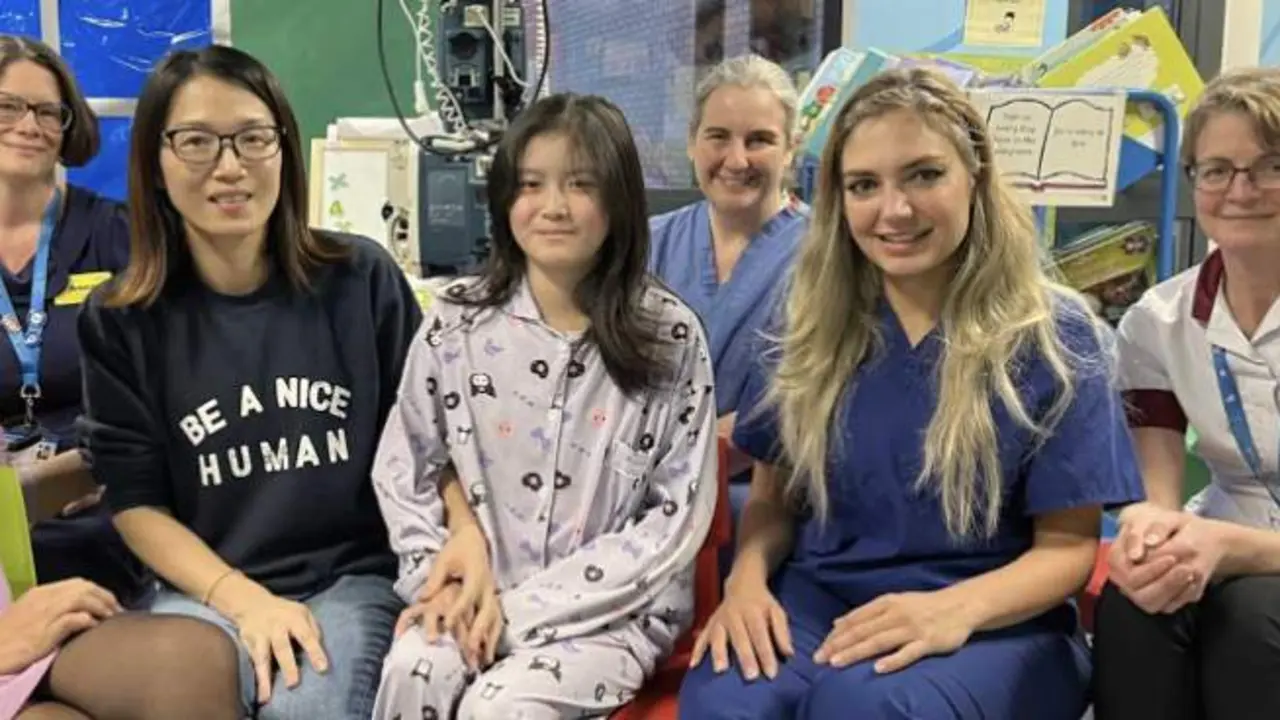  Kai Xue con su madre y miembros del equipo de los Hospitales Universitarios de North Midlands - NHS Trust via SWNS 