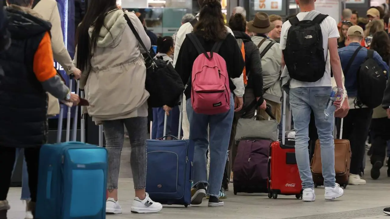  Numerosas personas con maletas salen de viaje en la estación Almudena Grandes-Atocha Cercanías | EP 