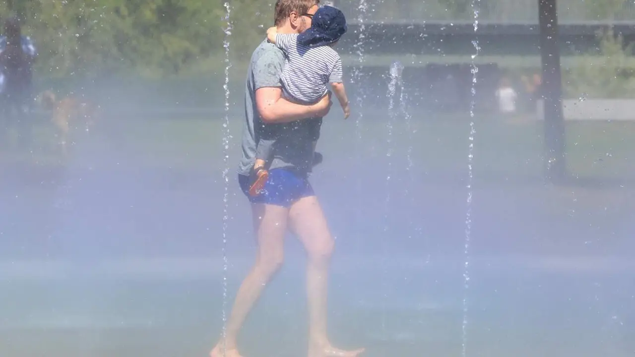  Archivo - Un hombre con su hijo pasa por los chorros de agua de la playa de Madrid R&iacute;o, a 24 de mayo de 2024, en Madrid (Espa&ntilde;a). Durante la visita, el alcalde ha comprobado c&oacute;mo se activa esta instalaci&oacute;n para combatir la llegada del calor. - Marta Fern&aacute;ndez Jara - Europa Press - Archivo 