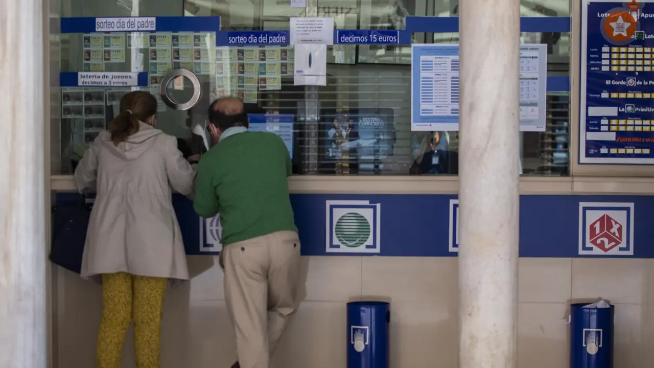  Archivo - Dos personas compran loter&iacute;a en una Administraci&oacute;n durante el primer d&iacute;a del proceso de desescalada instaurado por el Gobierno en el que los sorteos de EuroMillones y La Primitiva se reanudan en la semana del 18 al 24 de mayo, mientras que los d - Mar&iacute;a Jos&eacute; L&oacute;pez - Europa Press - Archivo 