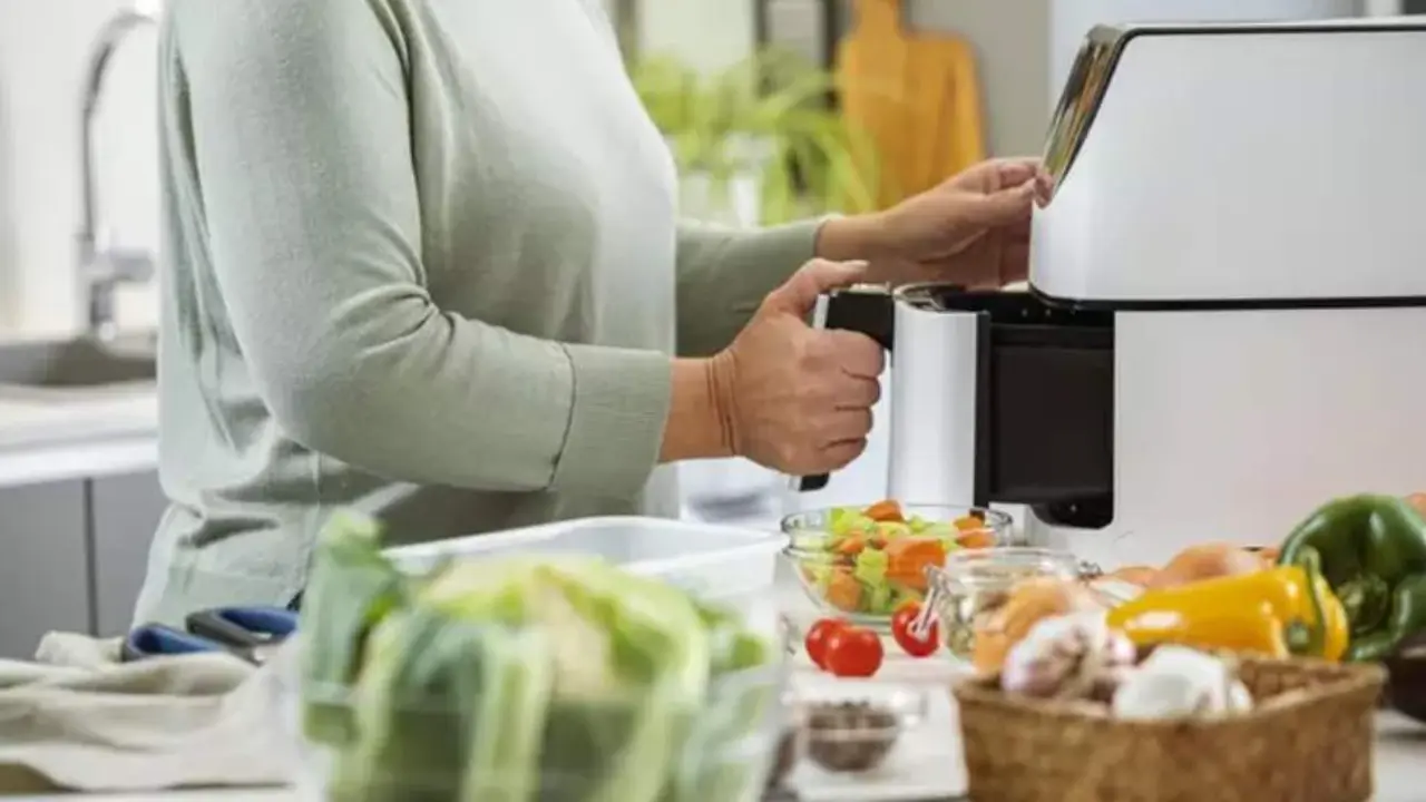  Una mujer utilizando su freidora de aire 