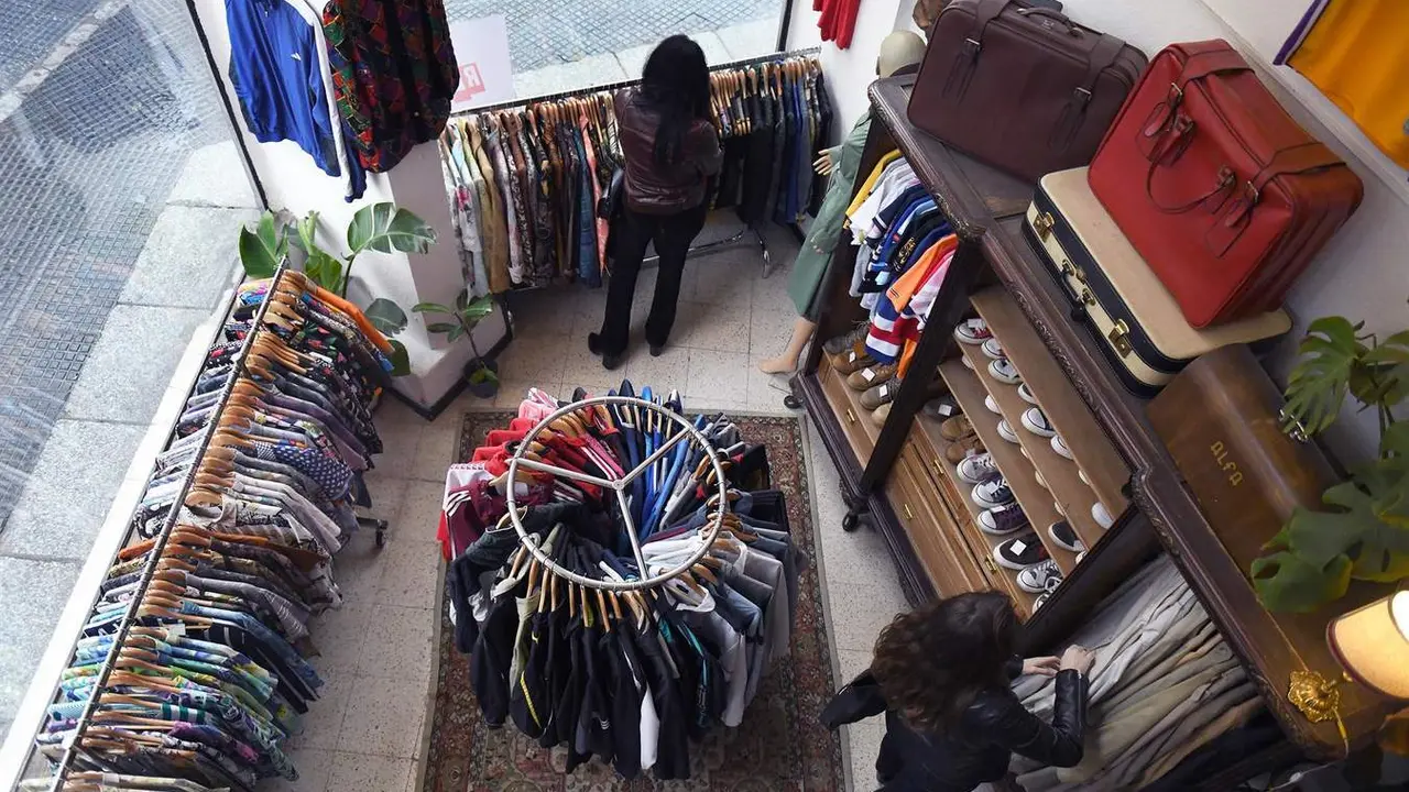  Una mujer mira ropa de segunda mano en un establecimiento 