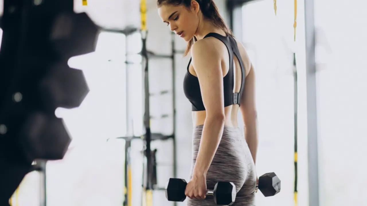  Archivo - Mujer joven haciendo deporte en un gimnasio levantando pesas. - QERES - Archivo 
