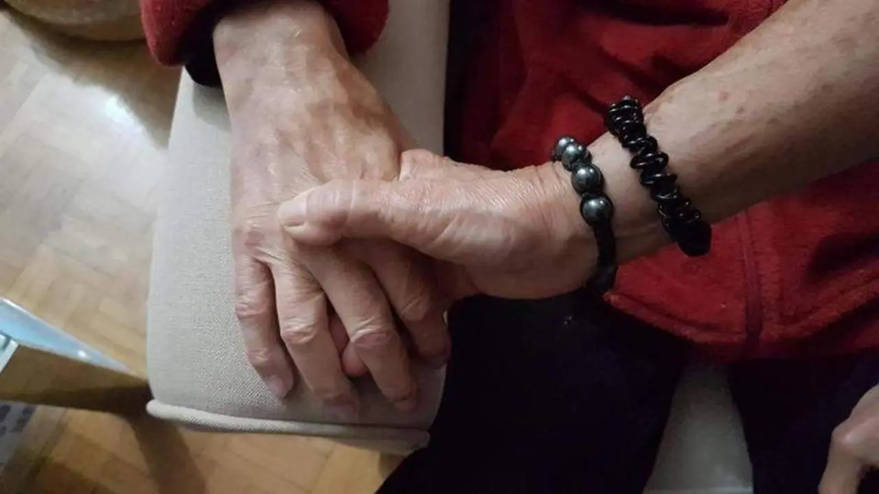  Pilar coge la mano de Valent&iacute;n, su marido, que tiene Alzheimer. 