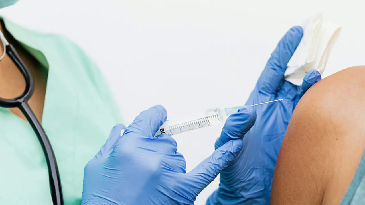  Una profesional sanitaria dispensa la vacuna frente al virus del papiloma humano a un adolescente 