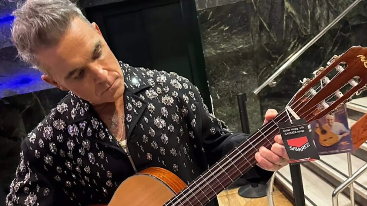  Robbie Williams con su guitarra - M&Uacute;SICOS POR LA SALUD 