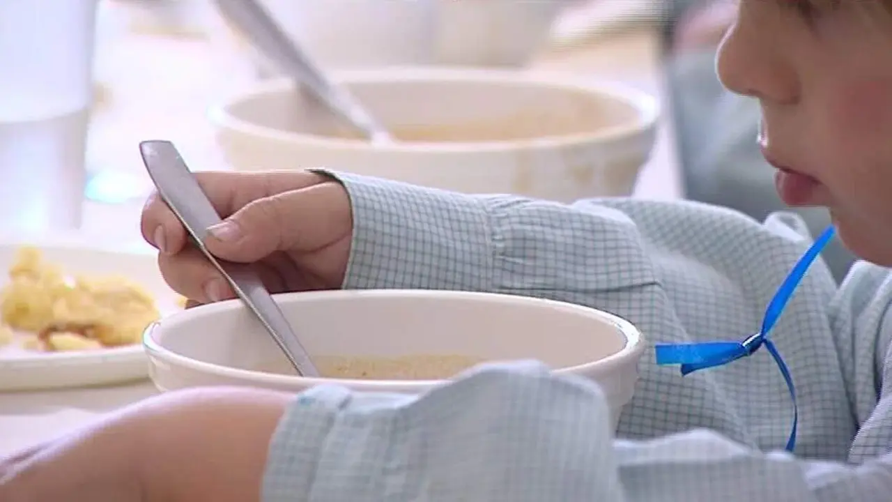  Ni&ntilde;o comiendo en un comedor escolar 