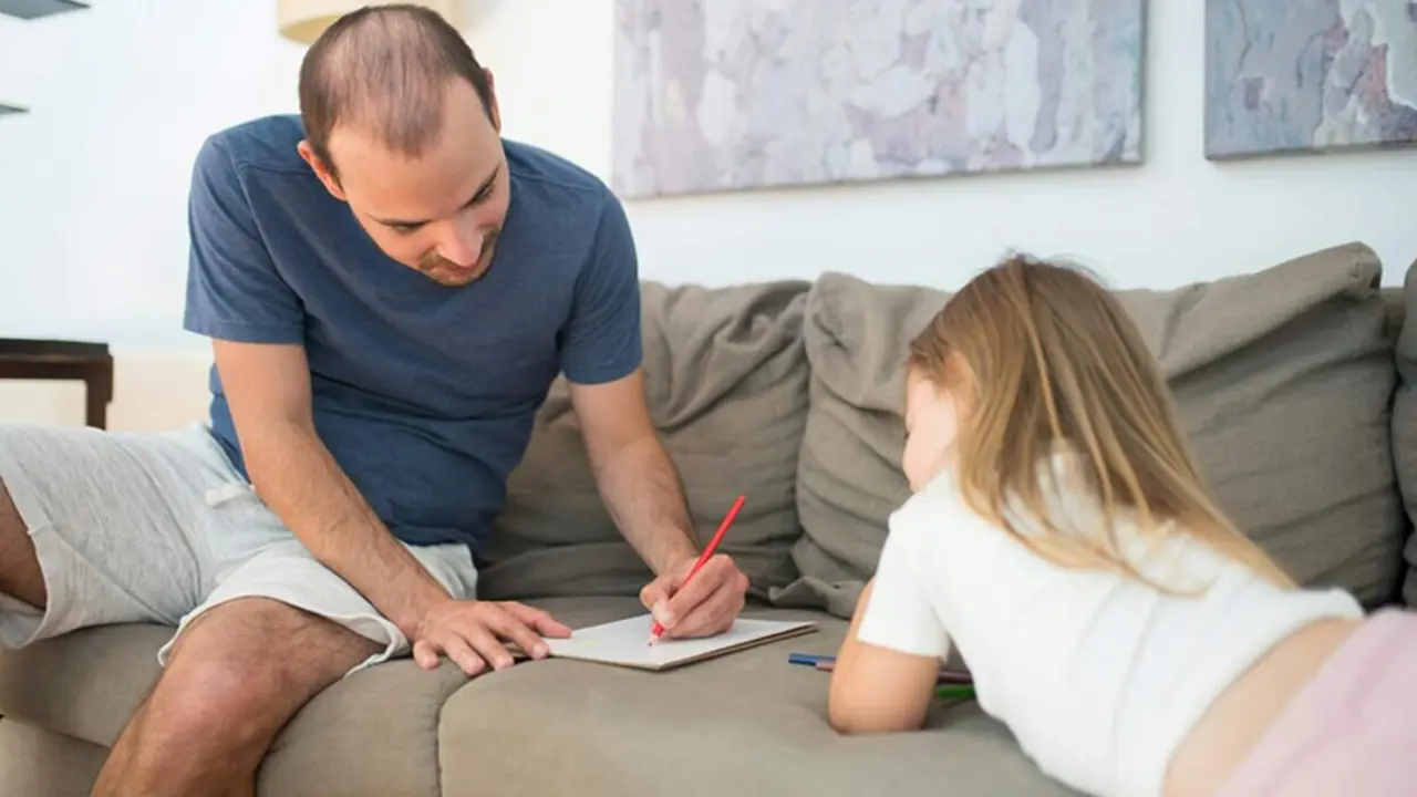  Un padre realiza una tarea escolar junto a su hija. 