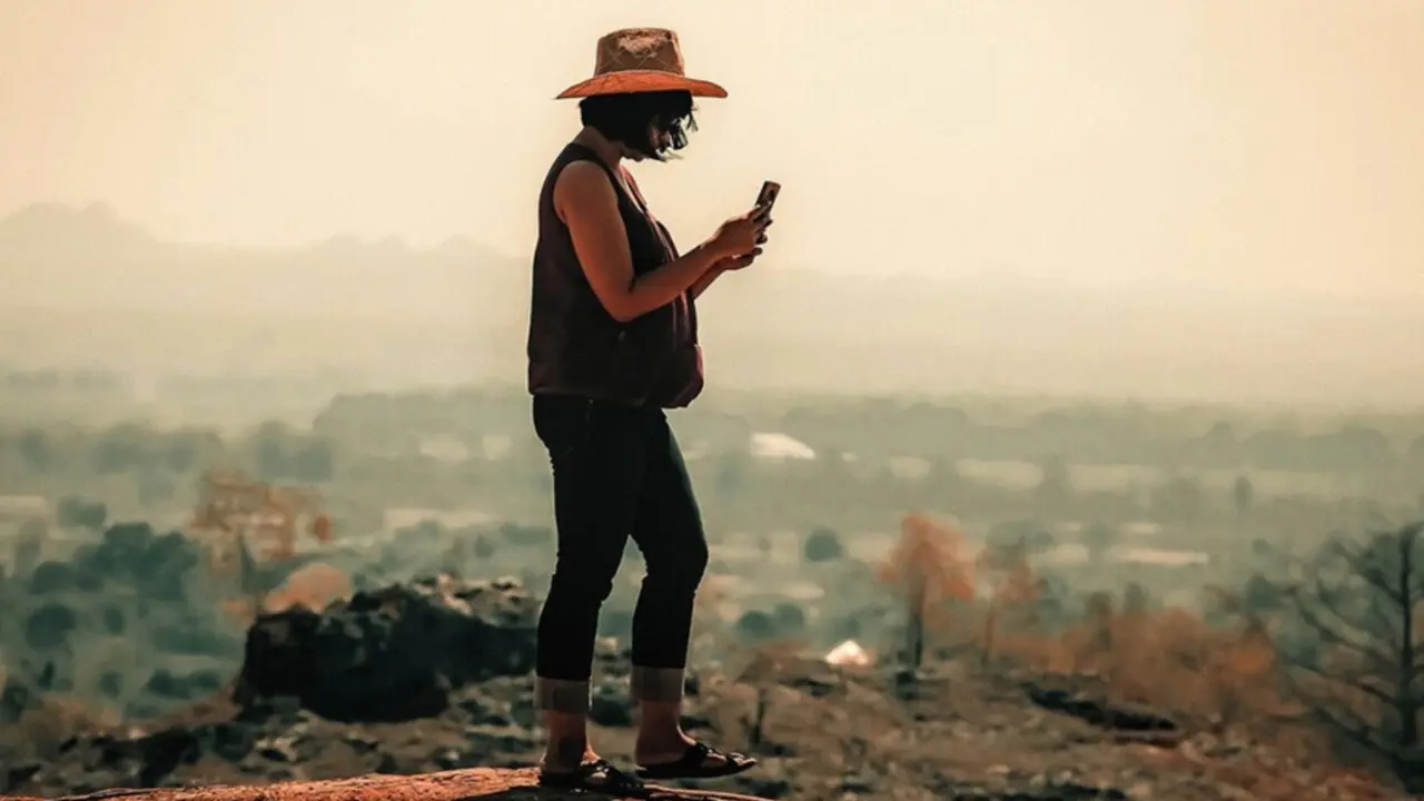  Una viajera intenta realizar una llamada con su tel&eacute;fono m&oacute;vil. 