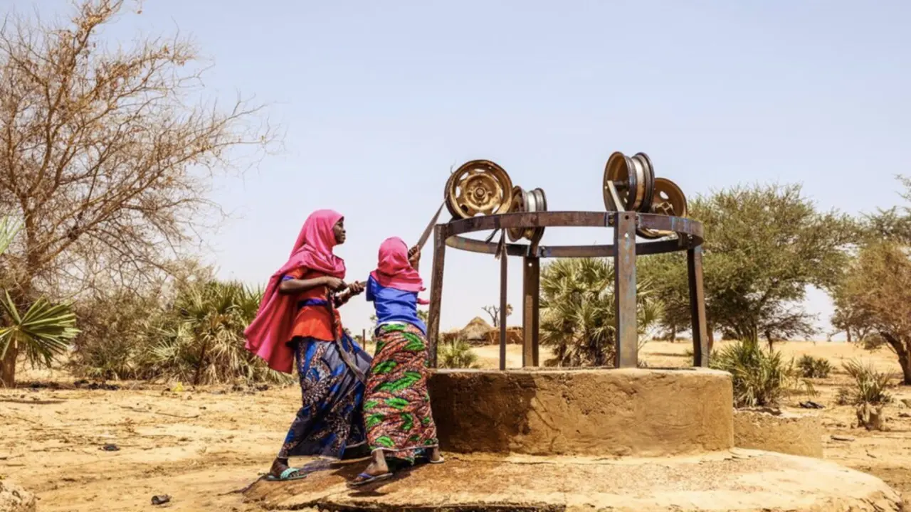  Mahana, 9, and her sister Firdaoussou, 12, get water from a well.The well has only had water for 4 days and is polluted with frogs and garbage. When this well runs dry, they will need to go further. - JON WARREN | EP 