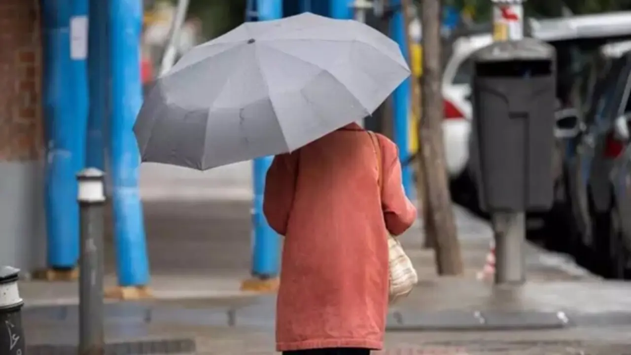  Archivo - Una mujer pasea por una calle con un paraguas. - EUROPA PRESS - DIEGO RADAM&Eacute;S - Archivo 