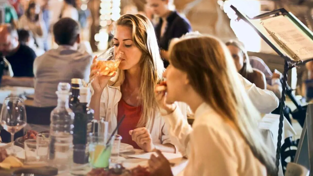 Dos j&oacute;venes almuerzan en un restaurante. 