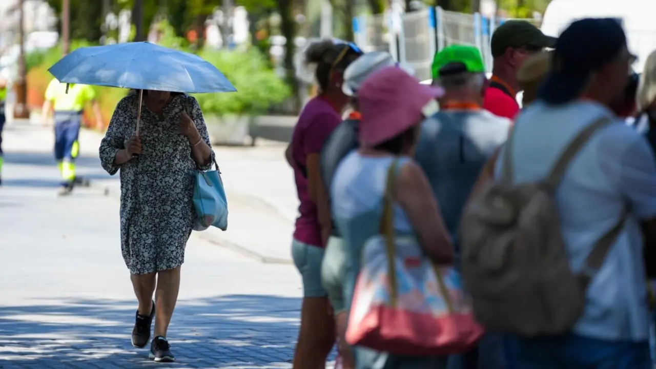 Una mujer con una sombrilla junto a un grupo de turistas. A 28 de mayo de 2025, en Sevilla (Andaluc&iacute;a, Espa&ntilde;a). - Mar&iacute;a Jos&eacute; L&oacute;pez - Europa Press