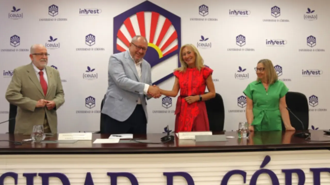  El rector y la presidenta de la AECC estrechan manos tras la firma del convenio. 