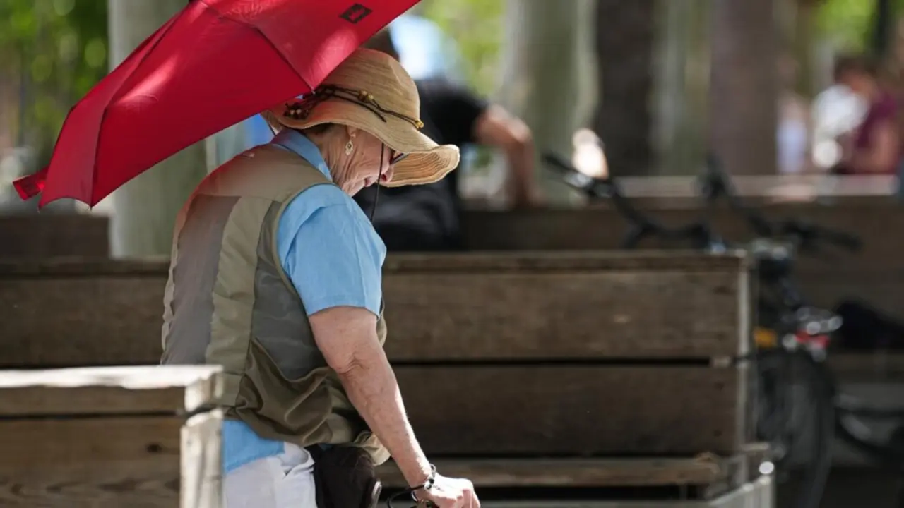  Archivo - Una mujer con sombrero y sombrilla paseando por puerta de Jerez. A 05 de julio de 2024, en Sevilla (Andaluc&iacute;a, Espa&ntilde;a). Andaluc&iacute;a afronta este martes la primera jornada de la segunda ola que se extender&aacute; hasta el jueves 25 de julio, tras la fina<br>- Mar&iacute;a Jos&eacute; L&oacute;pez - Europa Press - Archivo 