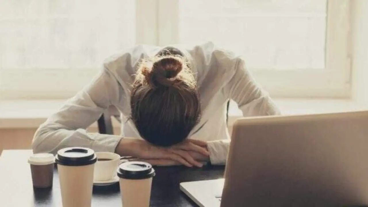  Trabajadora agobiada frente al port&aacute;til 