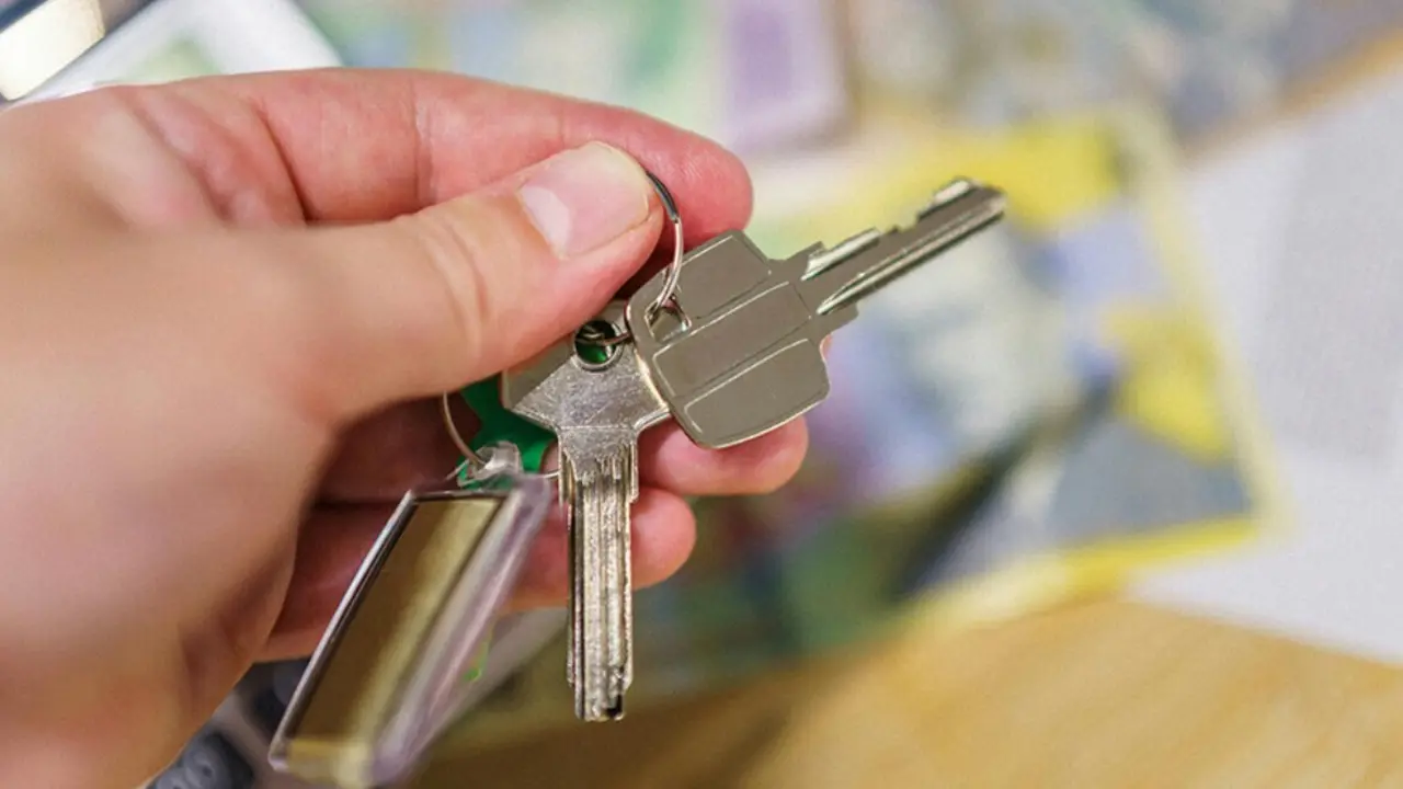  Una persona sostiene las llaves de una vivienda. 