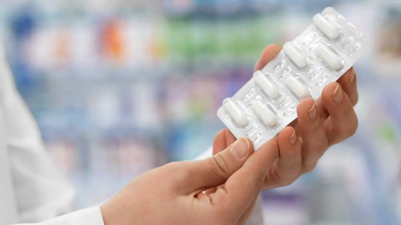  Una mujer muestra una tableta de pastillas. 