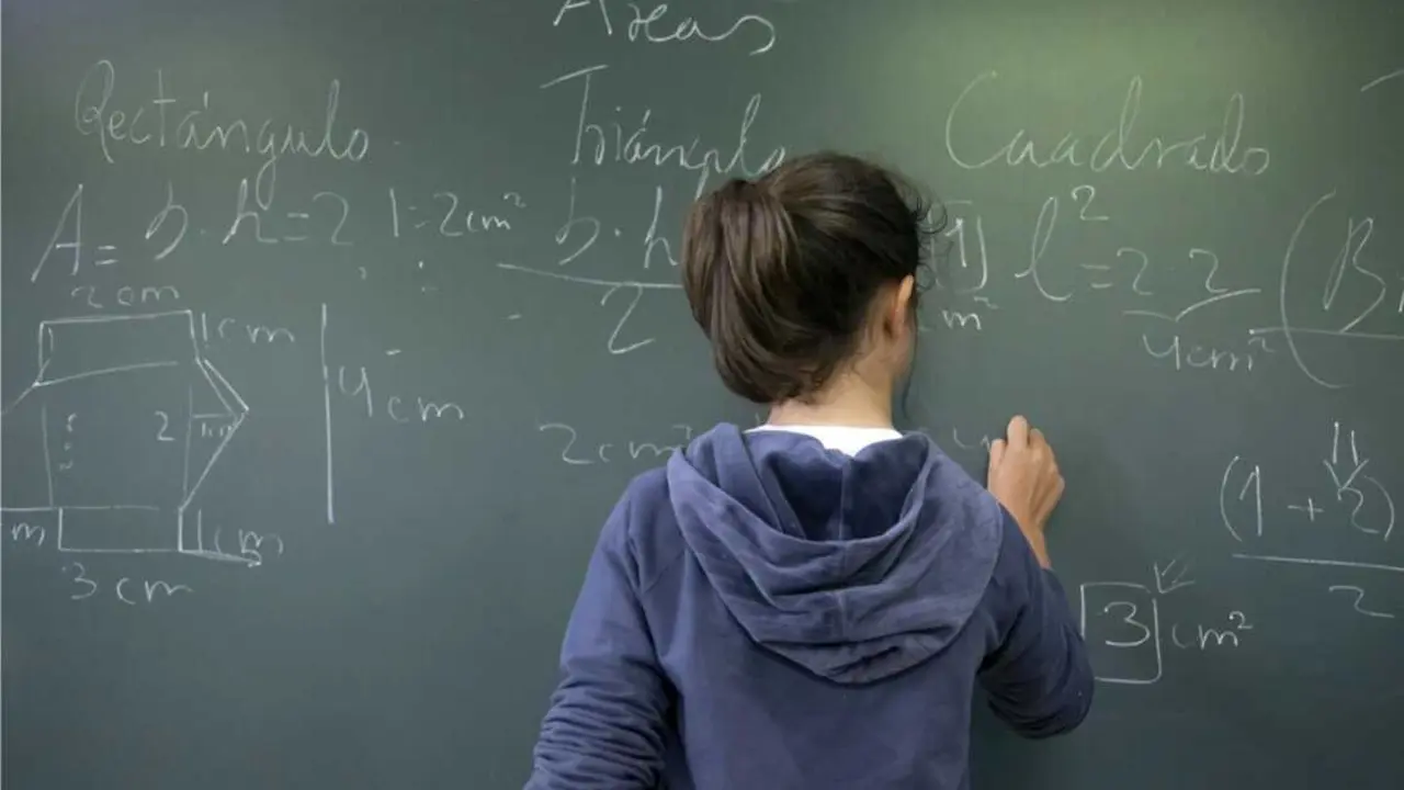  Archivo - Alumna escribe con tiza en una pizarra.<br>- XUNTA - Archivo 