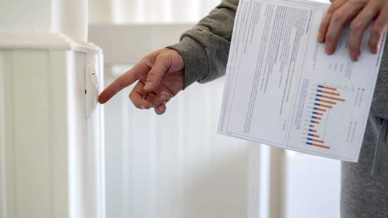  Un hombre enciende un interruptor con una factura de luz en la mano, a 3 de enero de 2022, en Madrid 
