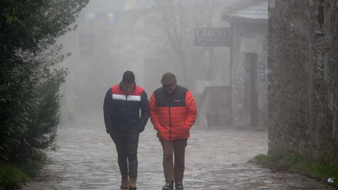 O Cebreiro, Pedrafita do Cebreiro, Lugo. Llega un frente frio que dejara nieve, lluvia y viento en el norte peninsular. En O Cebreiro, las temperaturas no han subido de los 3 grados y durante la noche ha caido una ligera nevada que no ha llegado a cuajar. En la imagen, dos hombres caminan entre la niebla en la aldea prerromana de O Cebreiro en la tarde del jueves 4 de noviembre