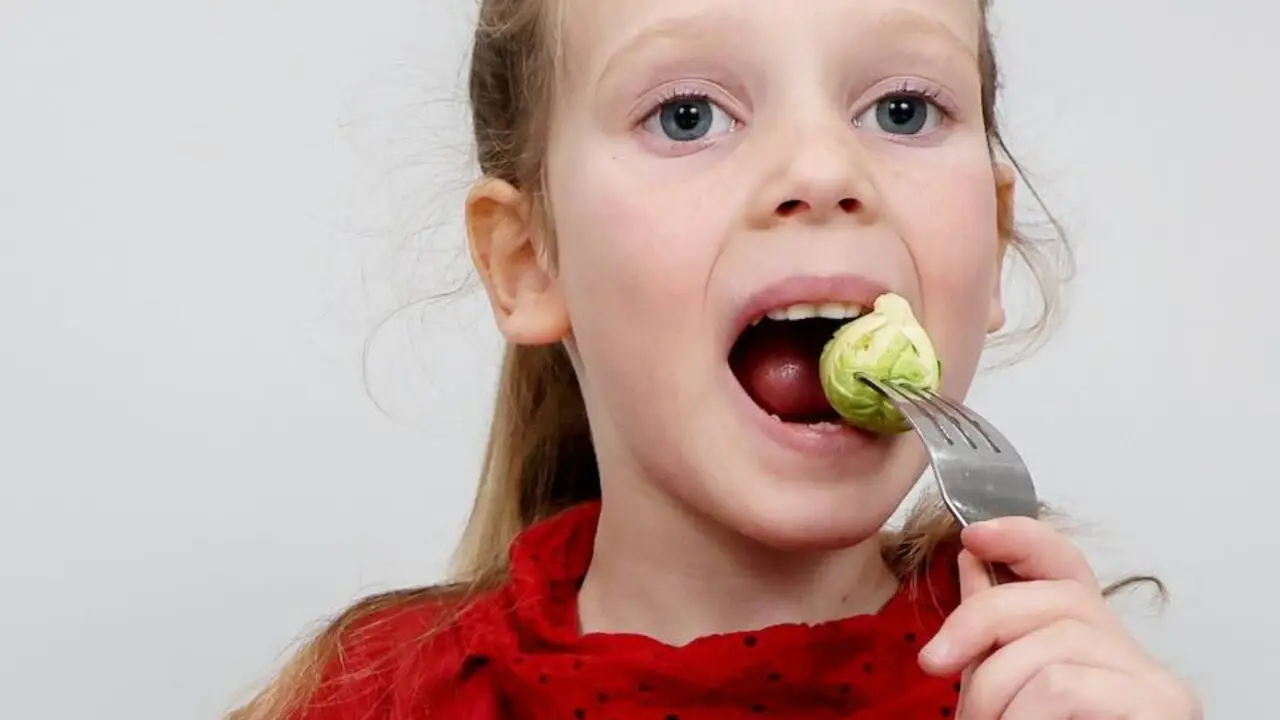 Emie comiendo las coles de Bruselas