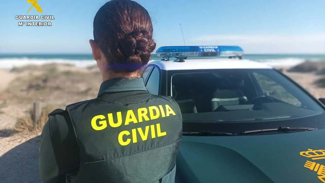 Agente de la Guardia Civil junto a un veh&iacute;culo