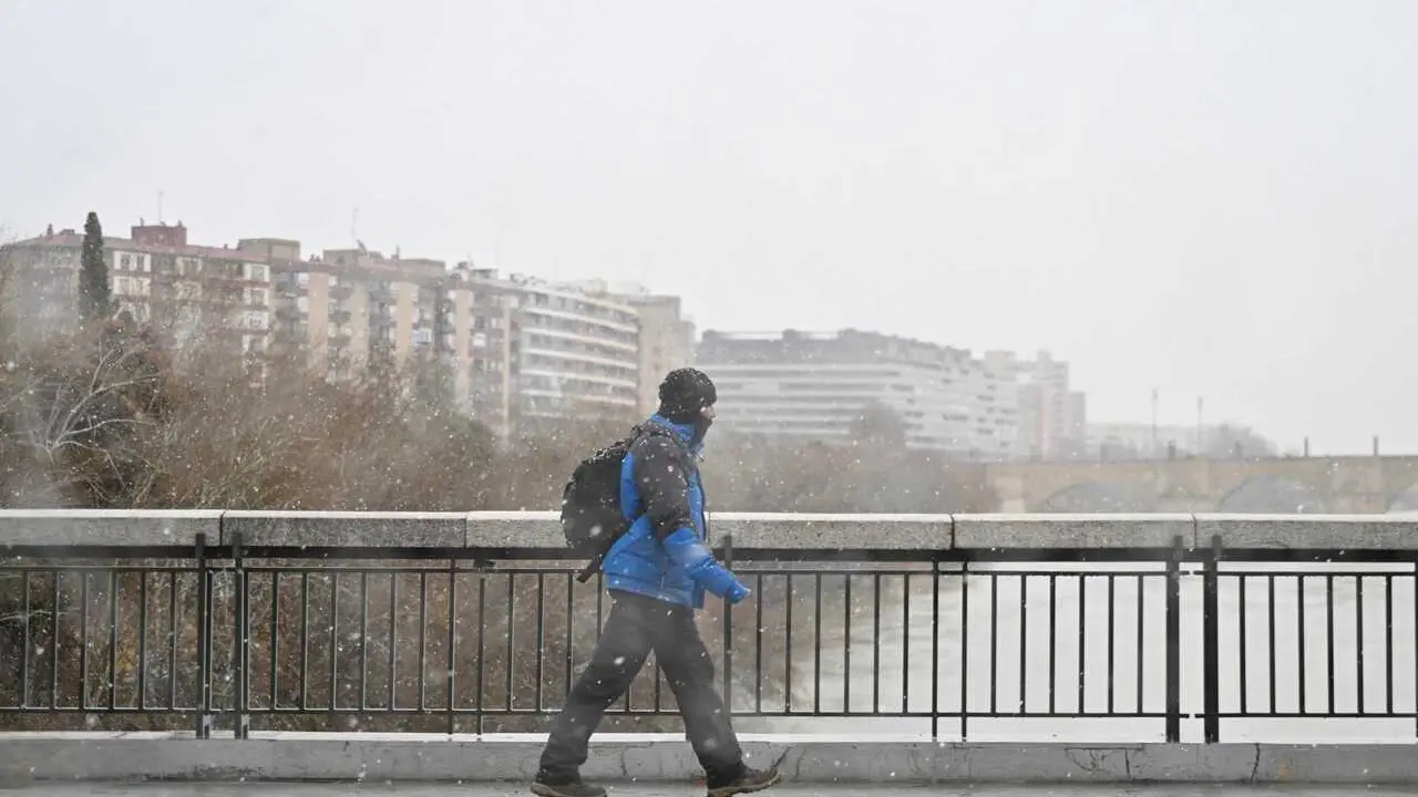 Archivo - Una persona camina por la calle bajo la nieve, a 19 de enero de 2024, en Zaragoza, Arag&oacute;n (Espa&ntilde;a). 