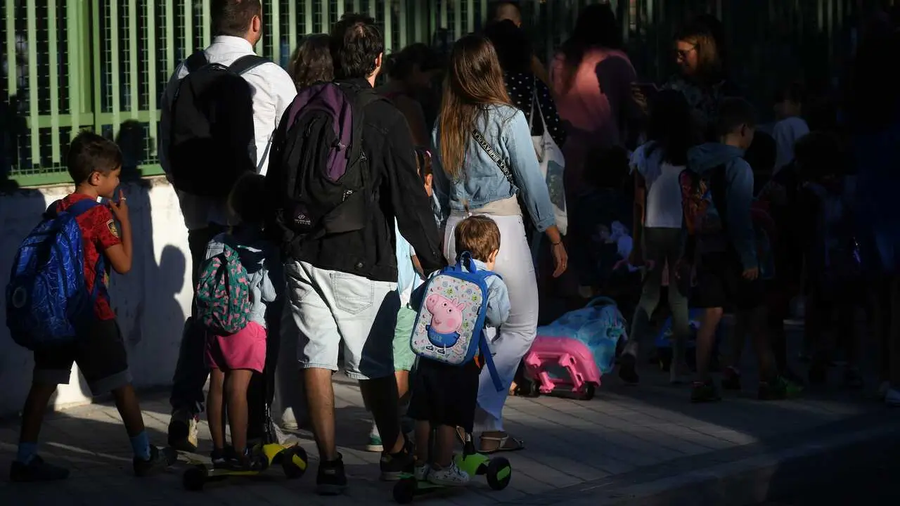 Archivo - Ni&ntilde;os y padres hacen cola para entrar al colegio  