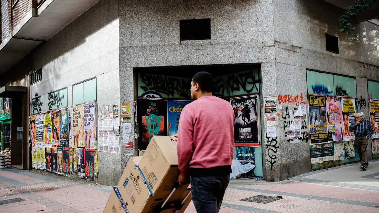 Archivo - Un repartidor carga con varias cajas.