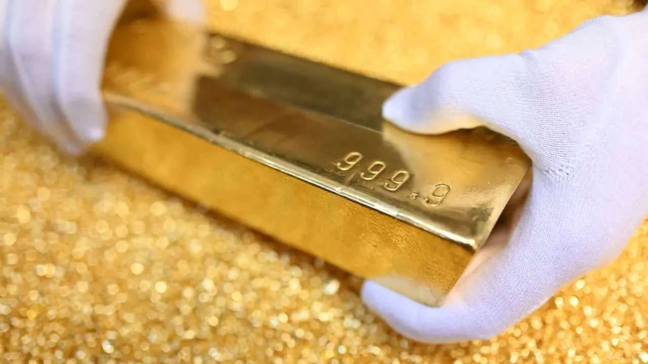 Archivo - FILED - 20 March 2023, Pforzheim: A gold bar weighing 12.5 kilograms is placed on gold granules at Agosi AG in Pforzheim. Photo: Uli Deck/dpa