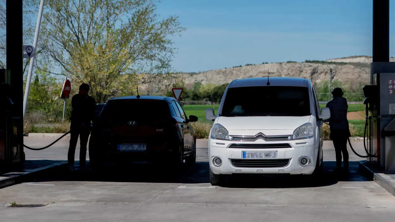 Archivo - Varias personas repostan en una gasolinera