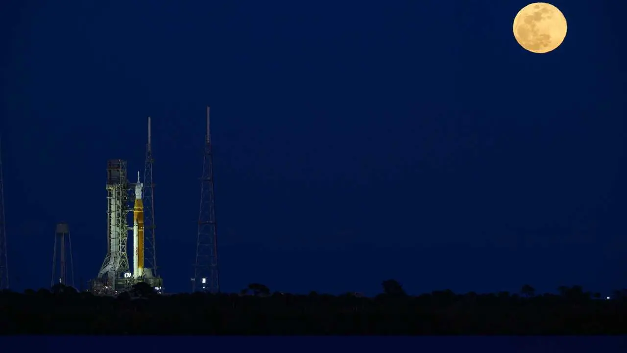 01 February 2026, US, Merritt Island: NASA's Space Launch System (SLS) rocket, with the Orion capsule atop, is seen on Launch Complex 39B, as the moon rises behind the rocket. A wet dress rehearsal is scheduled. A confirmed launch date will be decided bas