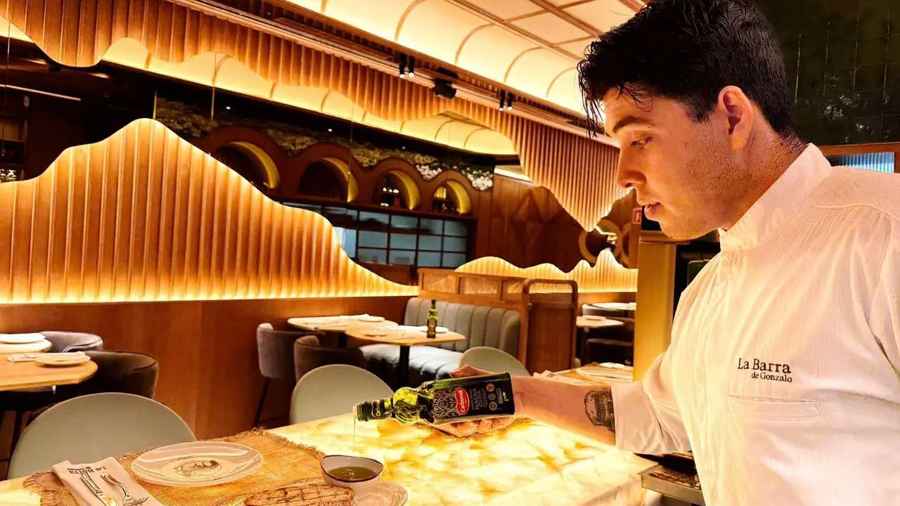 Camarero en restaurante mostrando los aceites de Deoleo