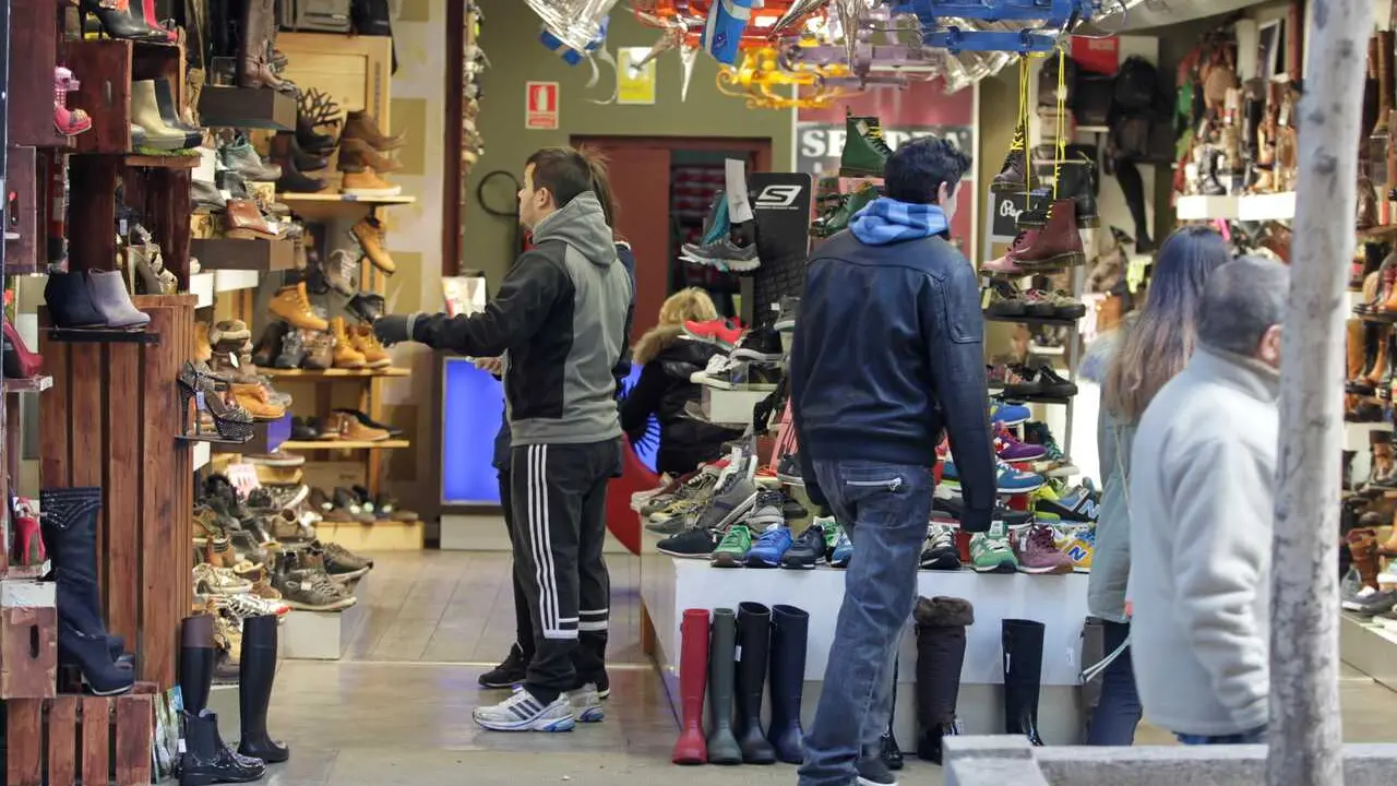 Archivo - Gente en una zapater&iacute;a