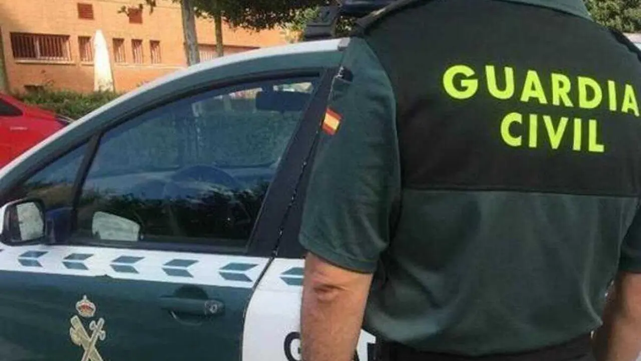 Archivo - Imagen de archivo de un agente de la Guardia Civil ante un coche patrulla