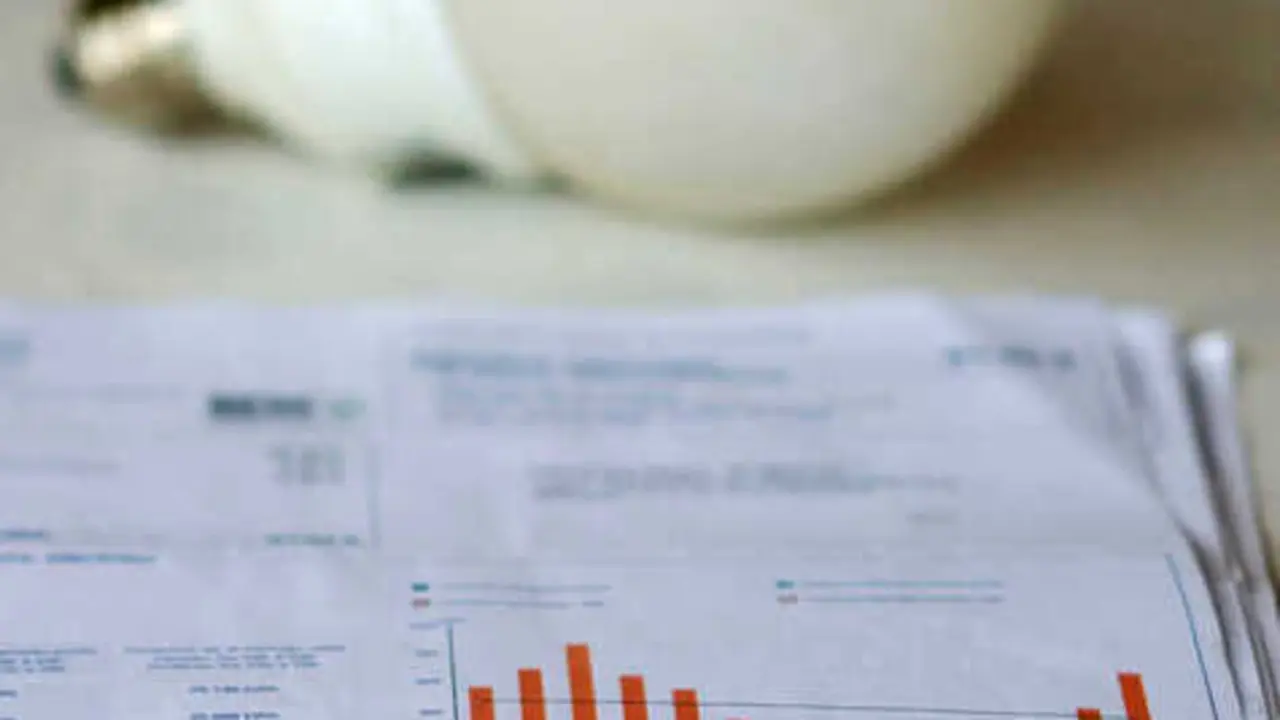   Archivo - Una factura de la luz y una bombilla  