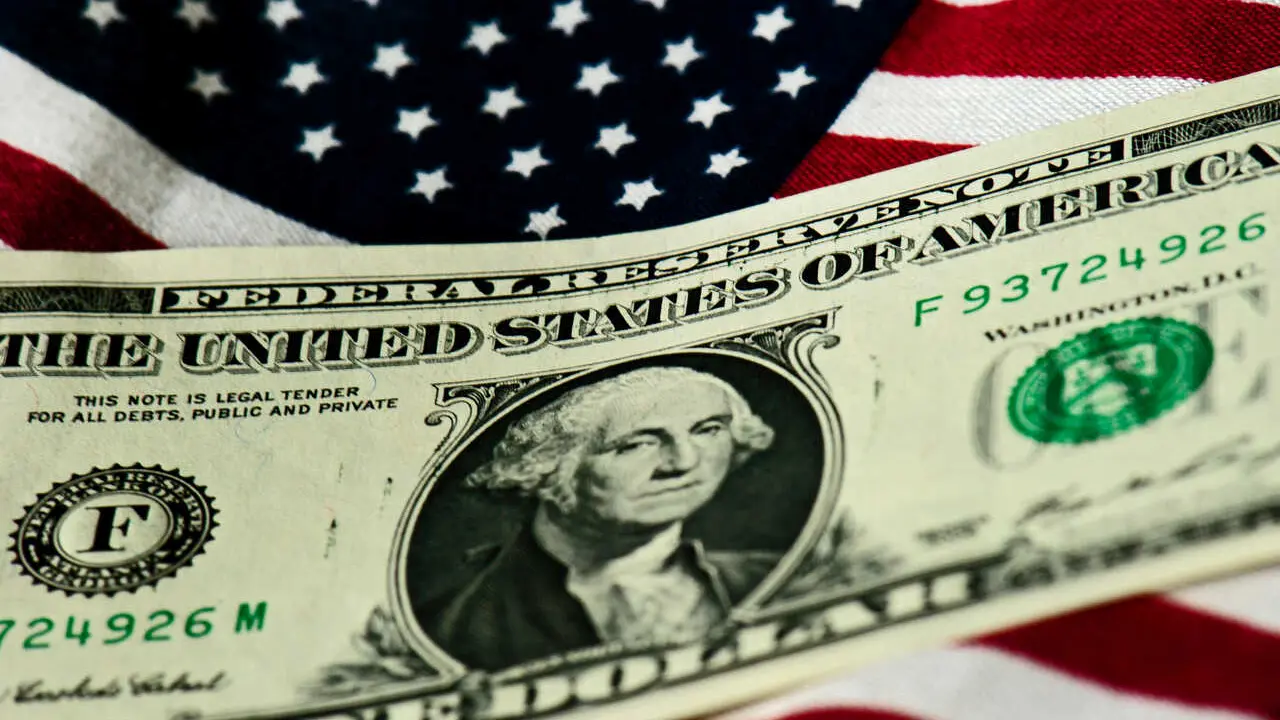 Archivo - FILED - 14 July 2011, Dresden: A US One Dollar is pictured on a US flag. Photo: Arno Burgi/dpa-Zentralbild/dpa