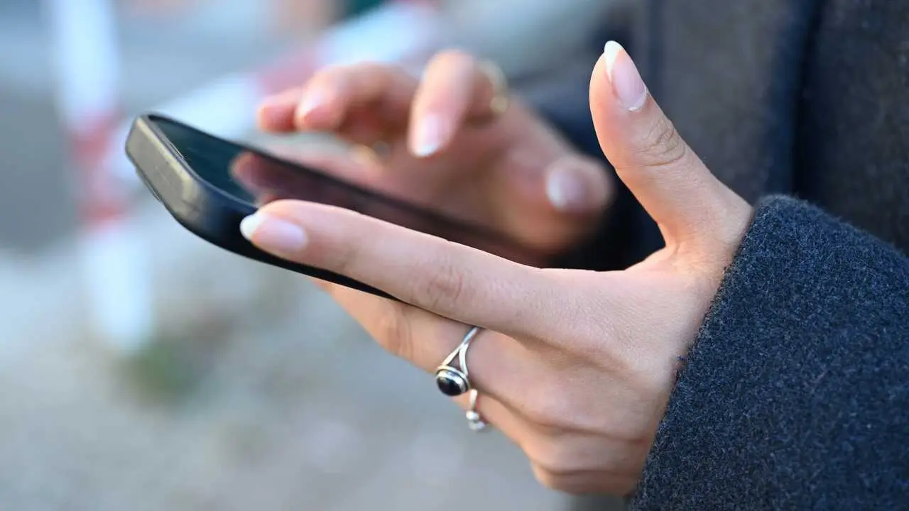 Archivo - Mujer usando su tel&eacute;fono