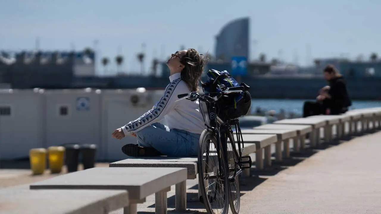 Archivo - Una mujer toma el sol en el paseo mar&iacute;timo de la playa del Bogatell, en Barcelona, Catalunya (Espa&ntilde;a). 