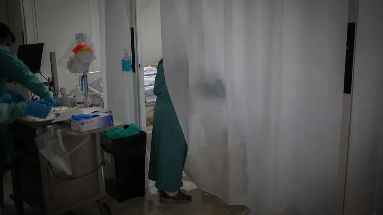 Archivo - Un sanitario visita a uno de los enfermos ingresado en uno de los boxes de la Unidad de Cuidados Intensivos &ndash;UCI- del Hospital de la Santa Creu i Sant Pau, integrado en la Red Hospitalaria de Utilizaci&oacute;n P&uacute;blica de Catalunya, en Barcelona (archi