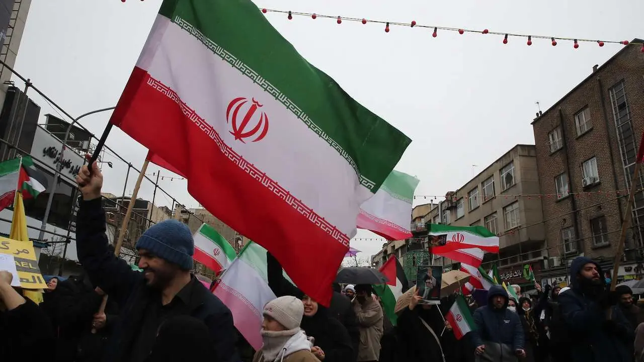 Un manifestante con una bandera de Ir&aacute;n en Teher&aacute;n