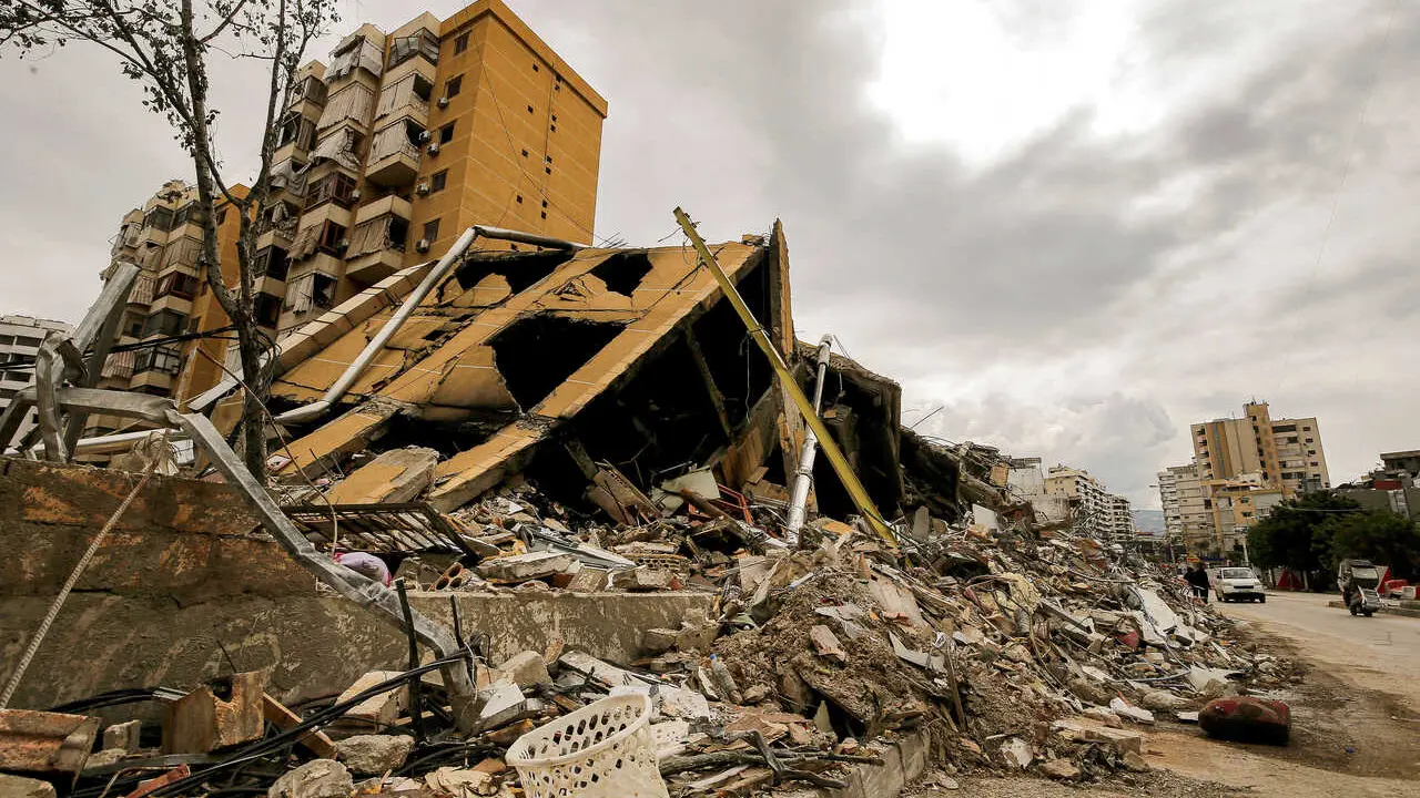 People walk past a destroyed building at the edge of the devastated Beirut southern suburb, a stronghold of pro-Iranian Hezbollah. Israel continued its attacks across Lebanon launching a fresh air strike south of Beirut. Lebanon was pulled into the Middle East war when Hezbollah began firing rockets into Israel on March 2 to avenge the killing of Iran&rsquo;s supreme leader Ali Khamenei.