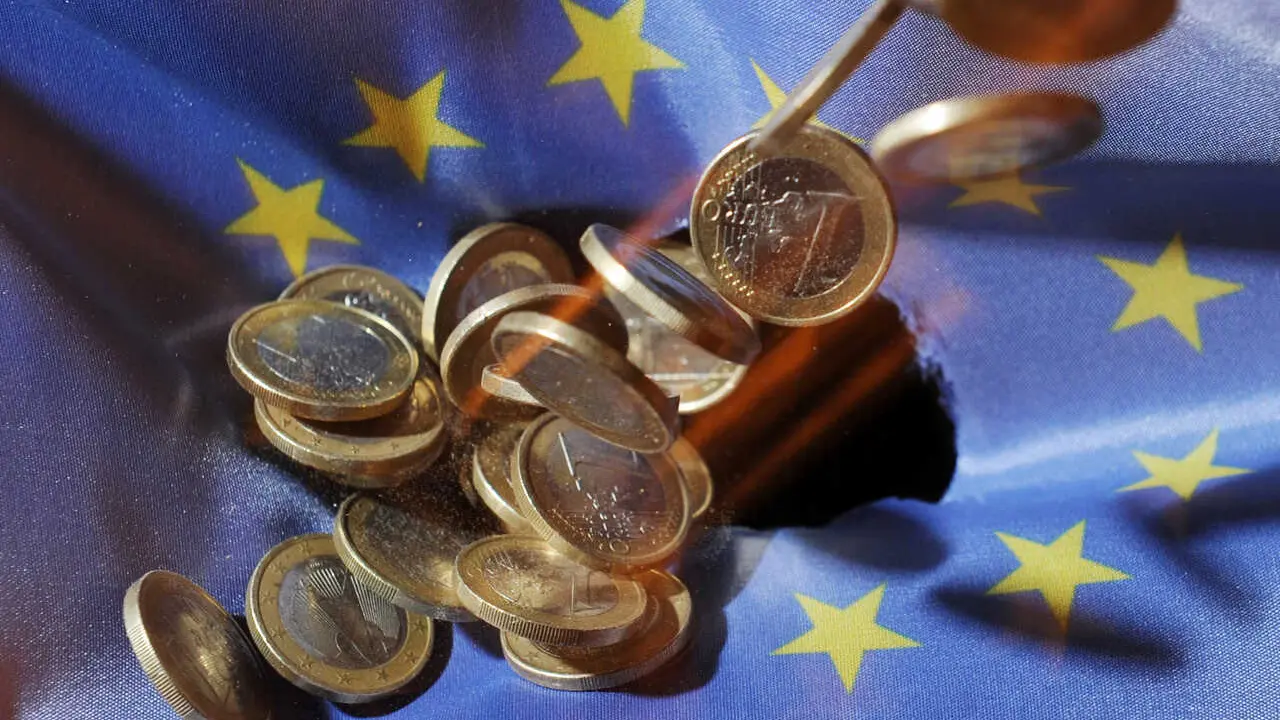 Archivo - FILED - 04 July 2011, Baden-Wuerttemberg, Karlsruhe: One euro coins will fall onto an EU&nbsp;flag. The European Union's gross domestic product shrank 3.5 per cent in the first three months of the year, according to a first estimate from Eurostat, wh